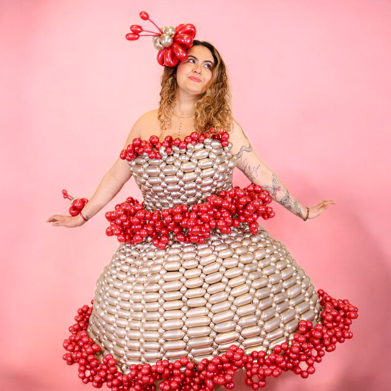 Model wearing a silver and red balloon dress sculpture by Sparky's Balloons